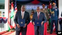 Ллойд Остин и Аден Дуале держат в руках копии подписанного двустороннего соглашения о сотрудничестве в области обороны в Найроби, Кения, понедельник, 25 сентября 2023 года.