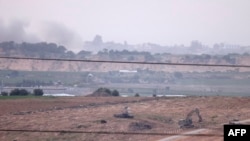 На снимке, сделанном с юга Израиля вдоль границы с сектором Газа, показаны танки и бульдозеры израильской армии, пересекающие границу с сектором Газа, 29 октября 2023 года на фоне продолжающихся боев между Израилем и палестинской группировкой боевиков ХАМАС