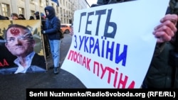 Надпись на плакате рядом с портретом Медведчука: вон из Украины, приспешник Путина