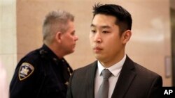 纽约市前警察梁彼得（右）离开布鲁克林高级法院（2016年2月11日）