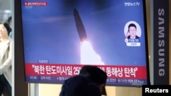 Люди смотрят по телевизору новостной репортаж о том, как Северная Корея запустила несколько ракет малой дальности в Сеуле, Южная Корея, 14 января 2025 года.