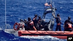 Экипаж судна «Оливер Генри» Береговой охраны США спасает трех моряков, которые оказались на мели на атолле Пайкелот, Федеративные Штаты Микронезии, 9 апреля 2024 года 