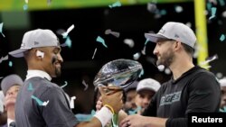 Игрок Philadelphia Eagles Джален Хёртс (слева) и главный тренер команды Ник Сирианни празднуют победу в Суперкубке LIX, держа в руках кубок Винса Ломбарди, 9 февраля 2025 года 