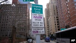 Знаки, информирующие водителей о плате за проезд, установлены у выезда из туннеля Линкольна в Нью-Йорке, среда, 19 февраля 2025 г. (AP Photo/Seth Wenig)