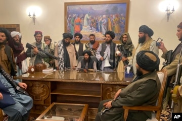 Hình minh họa - Máy bay trực thăng của Hoa Kỳ rời đi, trong khi chiến binh Taliban ngồi trên chiếc xe tăng bị bỏ hoang, bao quanh bởi những bông hoa anh túc đỏ.