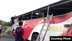 台湾桃园警方查看烧毁的旅游大巴，事故造成24名大陆游客、1名司机和1名导游遇难（台湾行政院提供 ） 