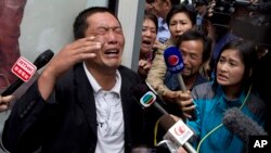 冀中星的哥哥冀中吉在对记者谈到弟弟时哭泣，其父在他身旁。